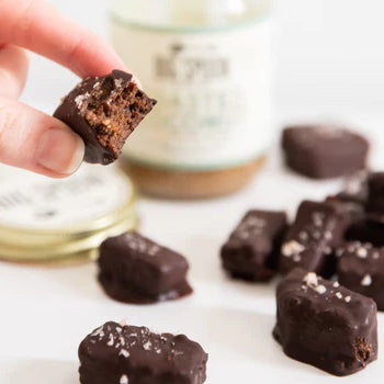 hand holding toasted coconut date caramel bites