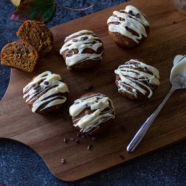 cutting board with glazed pumpkin muffins