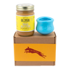 Jar of Banana Flax Wag Butter and a blue West Paw Toppl toy sit on top of a gift box with a gold and maroon decorative dog label.