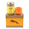 Jar of Banana Flax Wag Butter and a orange West Paw Toppl toy sit on top of a gift box with a gold and maroon decorative dog label.
