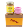 Jar of Banana Flax Wag Butter and a pink West Paw Toppl toy sit on top of a gift box with a gold and maroon decorative dog label.