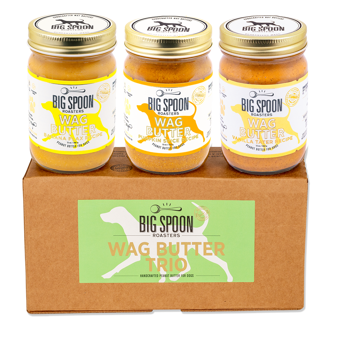 Three jars of Big Spoon Roasters Wag Butter on a cardboard box with the brand logo.